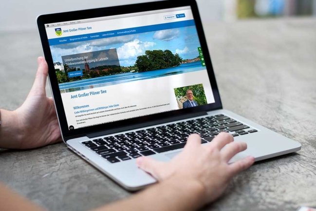 Ein Mann präsentiert die neue Website des Amtes Großer Plöner See am Laptop
